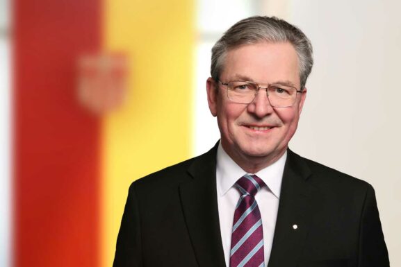 Bürgermeister Dreier und im Hintergrund Flagge mit Wappen.