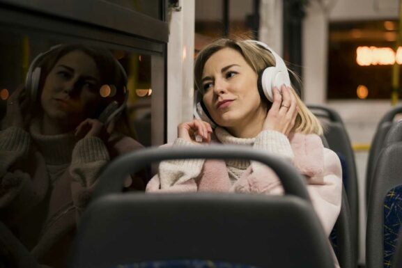 Frau mit Kopfhörer im Bus